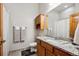 Bathroom features a granite countertop vanity, wood cabinets, a framed mirror and a tiled shower with curtain at 14434 W 88Th Dr # B, Arvada, CO 80005