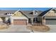 Charming home with a two-car garage, a covered entry, and manicured landscaping at 14434 W 88Th Dr # B, Arvada, CO 80005