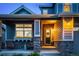 Inviting front porch with decorative stone pillars, a charming wreath, and cozy seating area at 4738 Colorado River Dr, Firestone, CO 80504