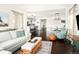 Bright living room with a sofa and decor leading to a modern open kitchen at 4738 Colorado River Dr, Firestone, CO 80504