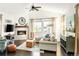 Cozy living room featuring a stone fireplace, hardwood floors, and large windows with natural light at 4738 Colorado River Dr, Firestone, CO 80504