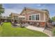 Charming backyard featuring a covered patio with outdoor dining and manicured lawn at 20058 E Dartmouth Dr, Aurora, CO 80013