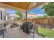 Cozy covered backyard patio area with a grill, seating, and lush green lawn at 20058 E Dartmouth Dr, Aurora, CO 80013