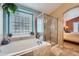 Bathroom featuring a large bathtub, glass shower, tile floors, and access to main bedroom at 20058 E Dartmouth Dr, Aurora, CO 80013