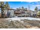 Spacious backyard with a deck and partial snow cover at 9593 Coronado Ct, Parker, CO 80134