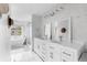 Bright bathroom featuring a double vanity, stylish mirrors, and separate soaking tub and shower at 20740 Parker Vista Rd, Parker, CO 80138