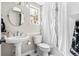 Cozy bathroom features pedestal sink, tiled floor, and shower with elegant white curtains at 20740 Parker Vista Rd, Parker, CO 80138