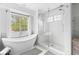 Spa-like bathroom featuring a soaking tub with window views and a glass enclosed shower with a seat at 20740 Parker Vista Rd, Parker, CO 80138