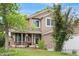 Charming two-story home featuring a welcoming front porch, well-manicured lawn, and beautiful landscaping at 20740 Parker Vista Rd, Parker, CO 80138