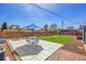 Landscaped backyard with a patio area, green lawn, and a modern horizontal wood fence providing privacy at 5000 W Dakota Ave, Denver, CO 80219