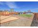 Backyard with a sand pit, grassy area, horizontal fence, and sheds for outdoor storage at 5000 W Dakota Ave, Denver, CO 80219