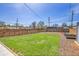 Well-maintained backyard featuring a green lawn, horizontal wood fence, and a landscaped perimeter at 5000 W Dakota Ave, Denver, CO 80219