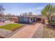 Charming home with a well-kept lawn, a modern fence, and a covered parking area at 5000 W Dakota Ave, Denver, CO 80219