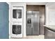 Convenient laundry area with stacked washer/dryer and stainless steel refrigerator at 5000 W Dakota Ave, Denver, CO 80219