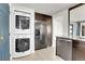 Functional laundry space featuring stacked washer/dryer, stainless fridge, and ample cabinet storage at 5000 W Dakota Ave, Denver, CO 80219