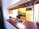 Cozy kitchen area with wood cabinets, black appliances, and breakfast bar at 2986 W 119Th Ave, Westminster, CO 80234