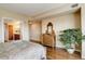 Bright bedroom featuring hard wood floors, a decorative dresser, and doorway to ensuite bathroom at 8100 E Union Ave # 1502, Denver, CO 80237