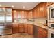Well-lit kitchen features stainless steel appliances, tile flooring, and natural wood cabinets at 8100 E Union Ave # 1502, Denver, CO 80237