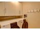 Laundry room features a white washer and dryer set with storage cabinets and hanging rack at 8100 E Union Ave # 1502, Denver, CO 80237