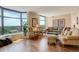 A lovely living room with large sunny windows showing views of trees and greenery at 8100 E Union Ave # 1502, Denver, CO 80237
