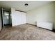 Neutral carpeted bedroom with a mirrored closet and a view of an en-suite bathroom at 1155 N Ash St # 908, Denver, CO 80220
