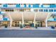 Modern high-rise building entrance with a covered walkway and well-maintained landscaping with planters at 1155 N Ash St # 908, Denver, CO 80220