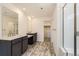 Bathroom featuring double sinks, walk-in shower with glass enclosure, and modern tile flooring at 10720 Snowdon St, Parker, CO 80134