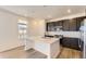 Modern kitchen with quartz countertops, stainless steel appliances, dark cabinets, and a kitchen island at 10720 Snowdon St, Parker, CO 80134