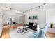 Bright living room featuring modern track lighting, a black sofa, and stylish blue armchairs at 960 N Sherman St # 2G, Denver, CO 80203