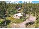 Aerial view of wood-sided single-story home with white roof surrounded by mature trees and a neighboring home at 10893 Milliken Ave, Conifer, CO 80433
