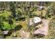 Aerial view of the property with a cabin-style house, a trampoline, and a storage shed in a wooded area at 10893 Milliken Ave, Conifer, CO 80433