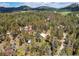 An aerial view captures the residence surrounded by an expansive forest, offering privacy and beautiful scenery at 10893 Milliken Ave, Conifer, CO 80433