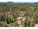 An aerial view of a forest with residences interspersed within a mountain community at 10893 Milliken Ave, Conifer, CO 80433
