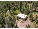 An overhead view of a wood-sided house nestled among trees, also showing sheds, trampoline, and stone details at 10893 Milliken Ave, Conifer, CO 80433