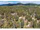 A beautiful aerial view of a home nestled amongst a lush forest with mountain views at 10893 Milliken Ave, Conifer, CO 80433