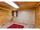 Wood-paneled bedroom featuring a plush red rug, skylight and a bright window, creating a rustic retreat at 10893 Milliken Ave, Conifer, CO 80433