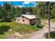 Aerial view of a modern house on a grassy lot surrounded by trees at 10893 Milliken Ave, Conifer, CO 80433