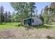 Outdoor shed sits on a grassy lot surrounded by trees at 10893 Milliken Ave, Conifer, CO 80433