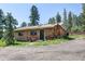 Charming stone and wood cabin featuring rustic details and a natural setting at 10893 Milliken Ave, Conifer, CO 80433