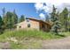 Angled exterior view of a bright, newly constructed home on a grassy lot at 10893 Milliken Ave, Conifer, CO 80433