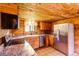 A cozy kitchen featuring wooden cabinetry, laminate countertops, and stainless steel appliances at 10893 Milliken Ave, Conifer, CO 80433