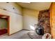 A cozy living room featuring a stone fireplace and an entrance to another room at 10893 Milliken Ave, Conifer, CO 80433