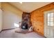 A charming living room featuring a stone fireplace and wood paneled walls at 10893 Milliken Ave, Conifer, CO 80433