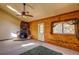 Cozy living room with stone fireplace, beamed ceiling, and bright, natural light at 10893 Milliken Ave, Conifer, CO 80433