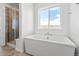 Modern bathroom with a soaking tub, walk-in shower, and large window at 39743 Penn Rd, Elizabeth, CO 80107
