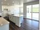 Modern kitchen with stainless appliances, large island, tile backsplash, and sliding glass door to backyard at 39743 Penn Rd, Elizabeth, CO 80107