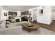 Open concept living room with dark wood floors, modern furnishings, and a seamless flow into the kitchen area at 39743 Penn Rd, Elizabeth, CO 80107