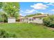 Large backyard with mature trees, privacy bushes, a garden shed, and an enclosed sunroom at 8622 W Warren Ln, Lakewood, CO 80227