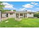 The backyard features a well-manicured lawn, a fire pit, and a sunroom, perfect for relaxation at 8622 W Warren Ln, Lakewood, CO 80227