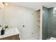 Modern basement bathroom with a wood vanity, tiled shower, storage shelves, and decorative floor tile at 8622 W Warren Ln, Lakewood, CO 80227